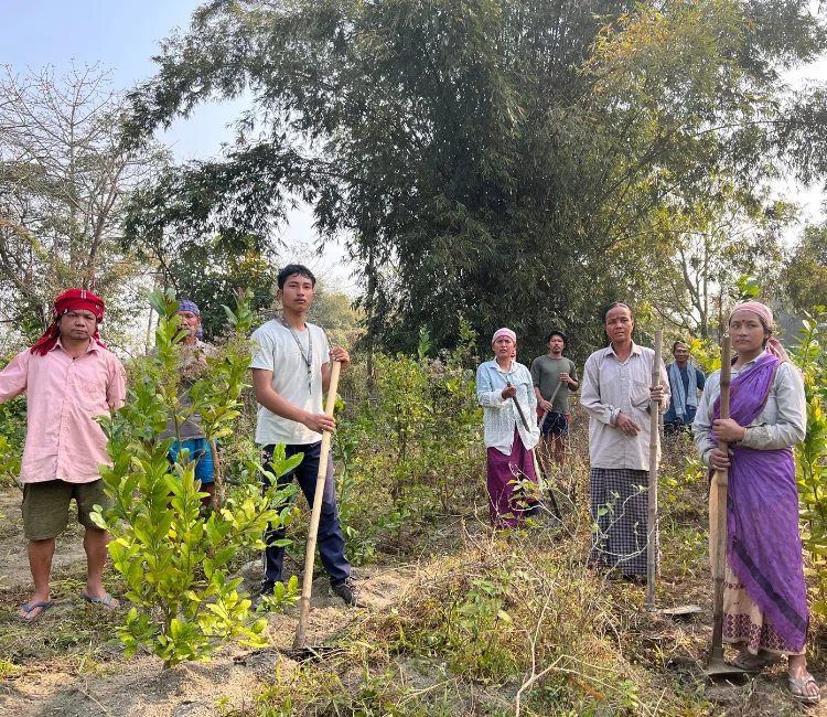 Community members with planting tools at a Balipara Foundation restoration site