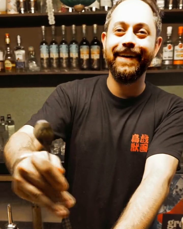A bartender at Nook grins across the terrazzo bar as he builds a drink